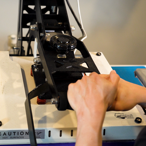heat press being used to press a dtf transfer on a shirt