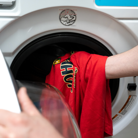 t-shirt with a DTF transfer design pressed on it being put into a washing machine